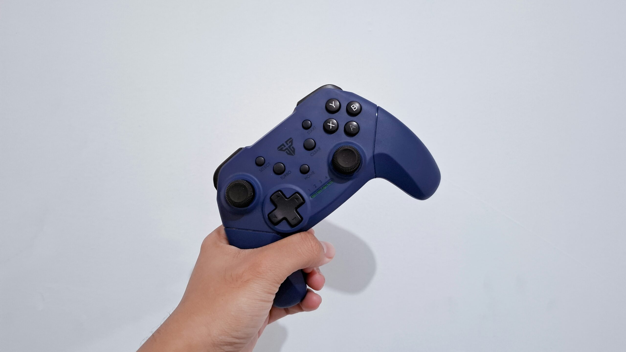 a hand holding a blue nintendo wii controller